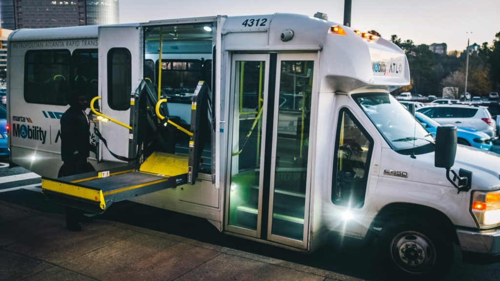 a city bus with its doors open and a ramp attached to it